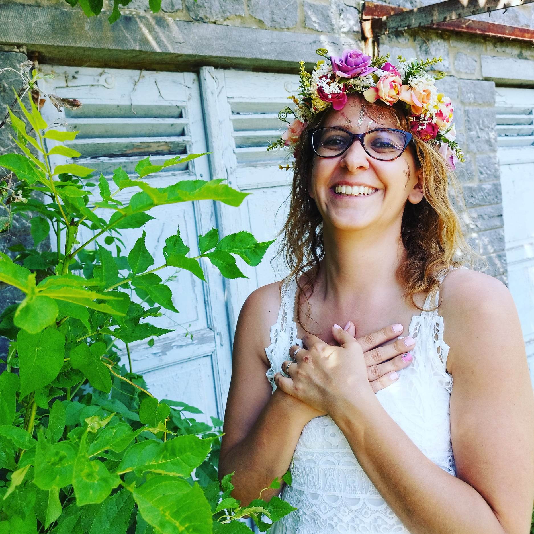 Caroline avec un grand sourire, couronne de fleurs sur la tête lors d'un mama blessing