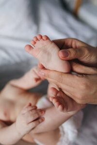 mains massant le pied d'un bébé